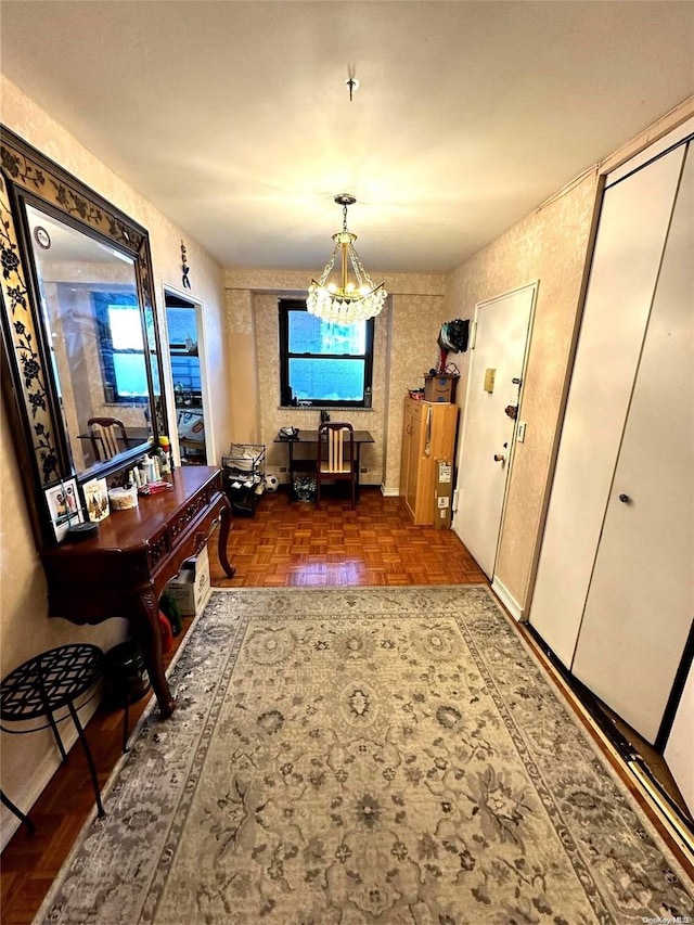 hallway with dark parquet floors, a wealth of natural light, and an inviting chandelier