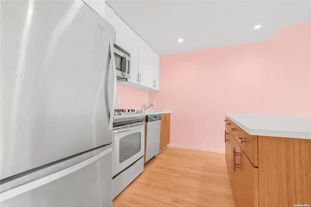 kitchen featuring sink, white cabinets, stainless steel appliances, and light hardwood / wood-style floors