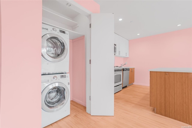 laundry area with light wood-type flooring and stacked washer / dryer