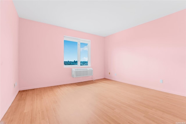 spare room with light hardwood / wood-style flooring and a wall mounted air conditioner