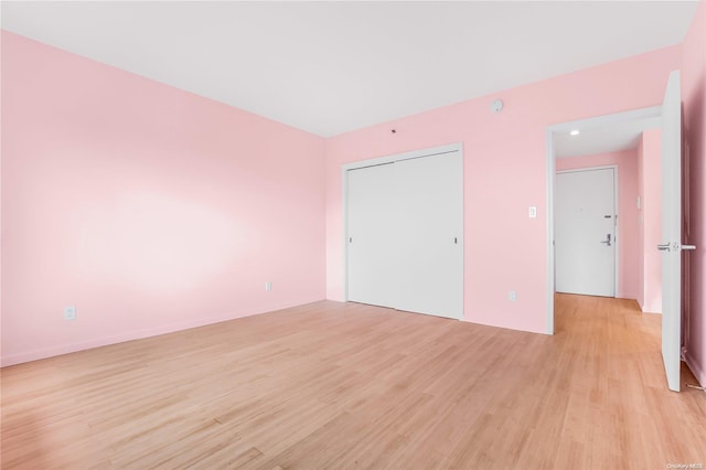 unfurnished bedroom featuring light wood-type flooring and a closet