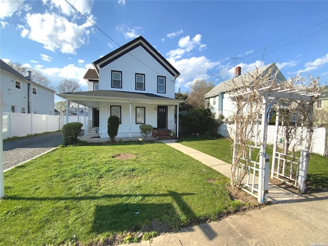 view of front of home with covered porch and a front lawn