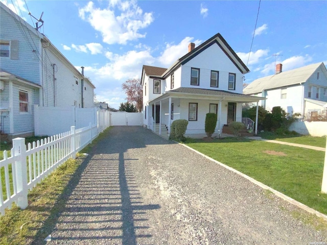 view of front of house with covered porch and a front lawn