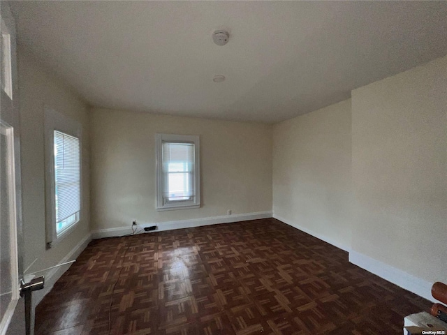 unfurnished room with dark parquet flooring