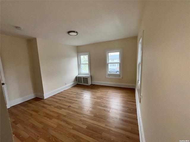 unfurnished room with radiator and light hardwood / wood-style flooring