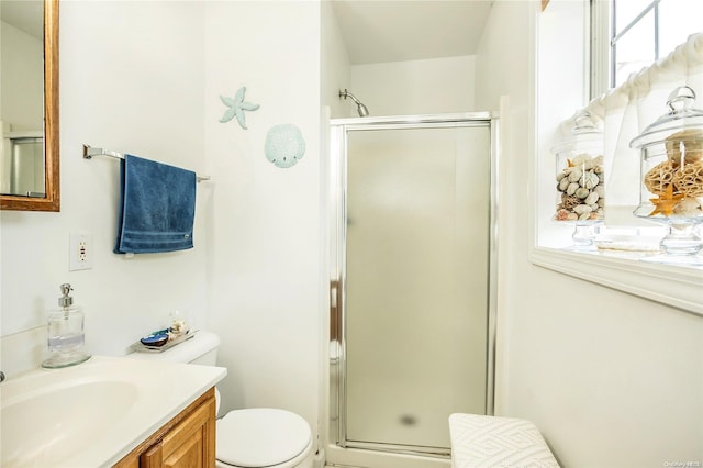 bathroom with a shower with door, vanity, and toilet