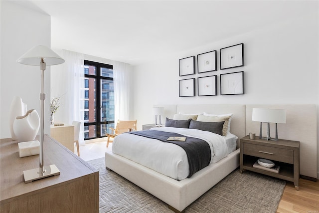 bedroom with light wood-style floors and french doors