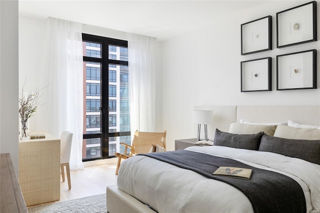 bedroom featuring light wood finished floors and french doors