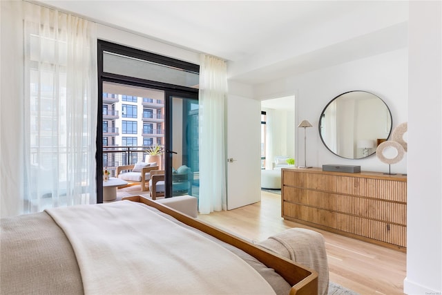 bedroom with light wood-type flooring and access to outside