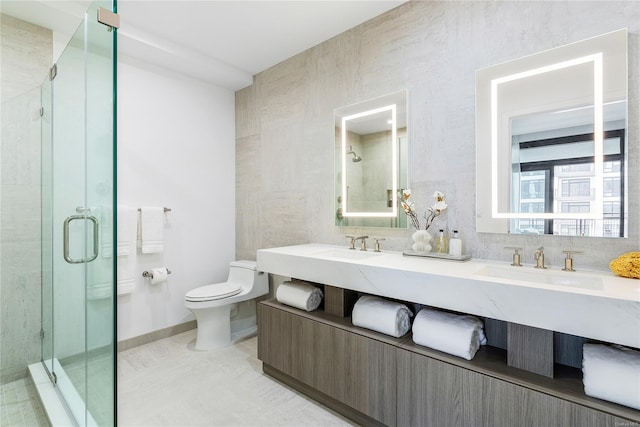 full bathroom featuring double vanity, a stall shower, toilet, a sink, and tile walls