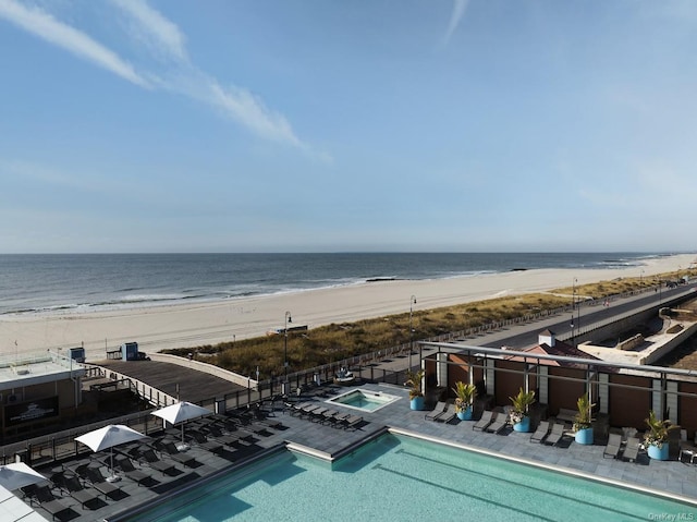 exterior space with a water view, a patio area, and a beach view