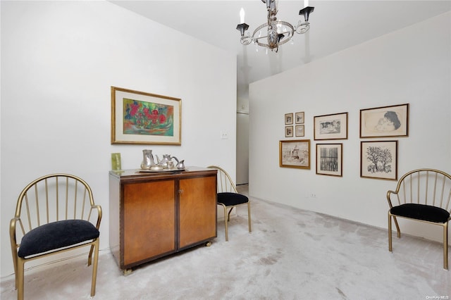 sitting room featuring light colored carpet and an inviting chandelier