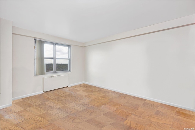 empty room with radiator and light parquet floors