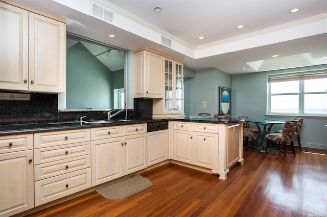 kitchen featuring dark stone counters, sink, crown molding, dark hardwood / wood-style flooring, and kitchen peninsula