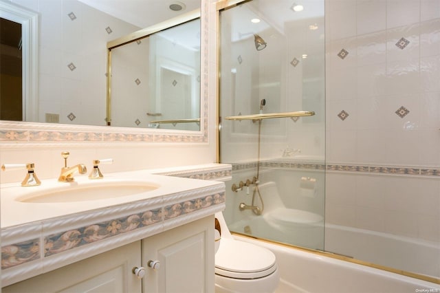 full bathroom featuring toilet, vanity, and combined bath / shower with glass door