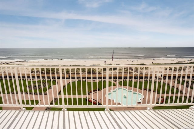 balcony featuring a view of the beach and a water view