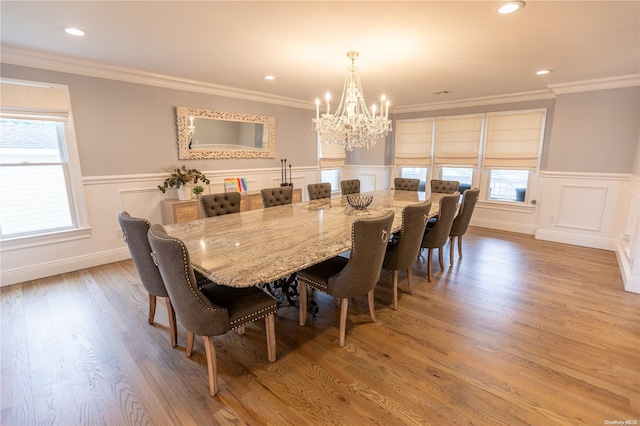 dining room featuring a chandelier, light hardwood / wood-style floors, and crown molding