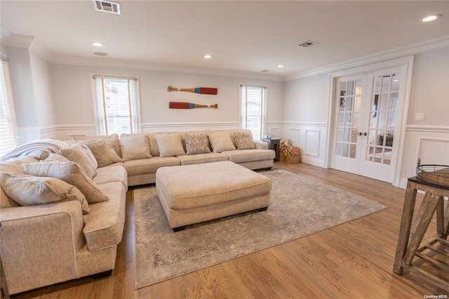 living room with crown molding, french doors, a healthy amount of sunlight, and wood-type flooring