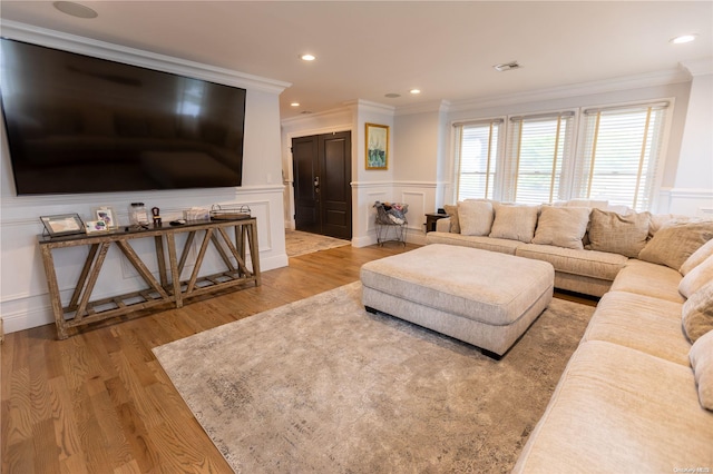 living room with crown molding and light hardwood / wood-style flooring