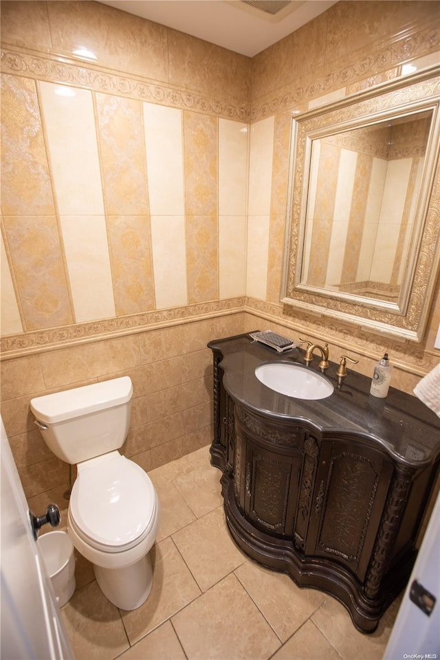 bathroom featuring tile patterned floors, vanity, toilet, and tile walls