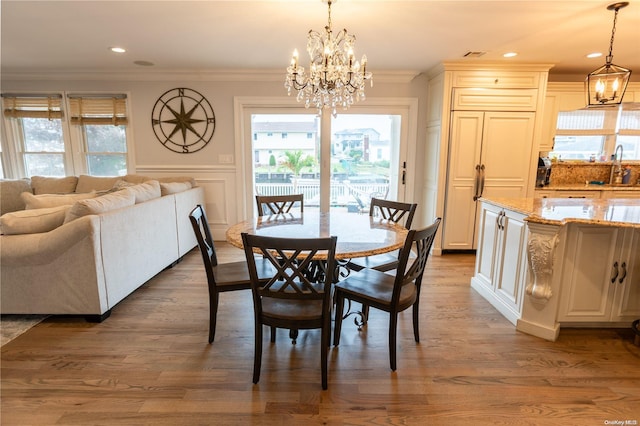 dining room featuring sink, a notable chandelier, dark hardwood / wood-style flooring, and crown molding