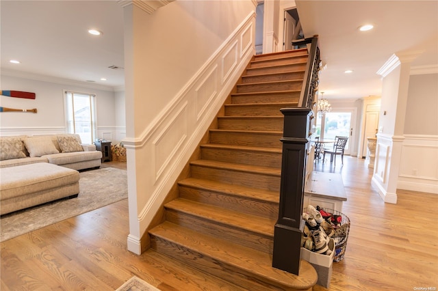 staircase with hardwood / wood-style flooring, plenty of natural light, and ornamental molding