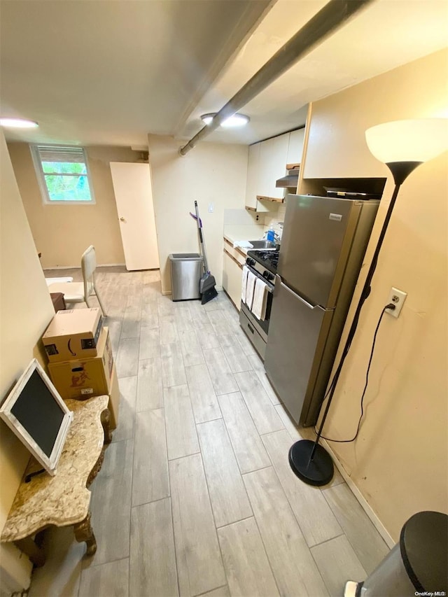 kitchen with light wood-type flooring, stainless steel appliances, and white cabinetry