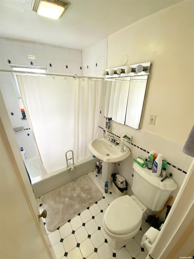 full bathroom with tile walls, sink, shower / tub combo, and toilet