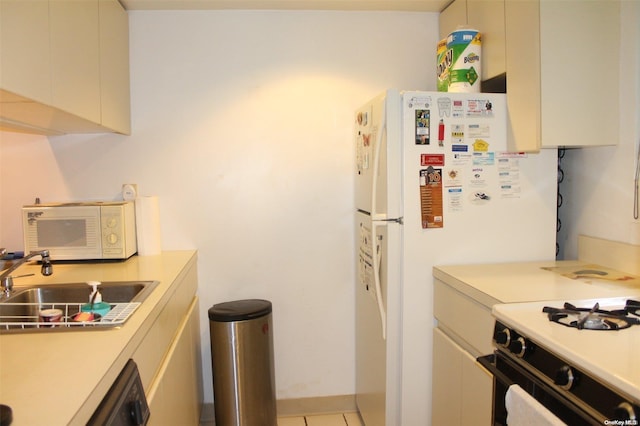 kitchen featuring cream cabinetry, white appliances, light tile patterned flooring, and sink