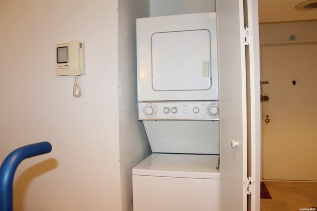 laundry area with tile patterned floors and stacked washer and clothes dryer