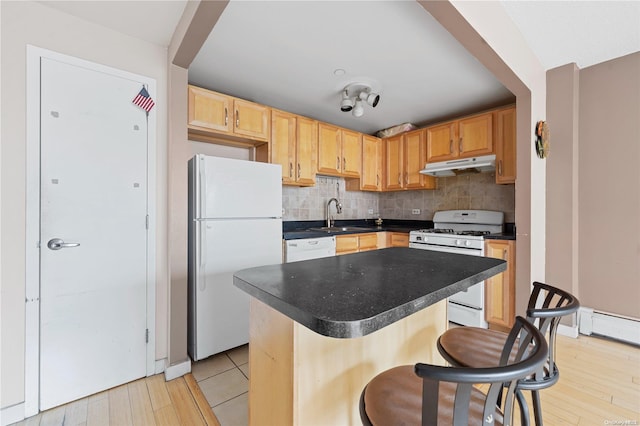 kitchen with decorative backsplash, white appliances, light hardwood / wood-style floors, and sink