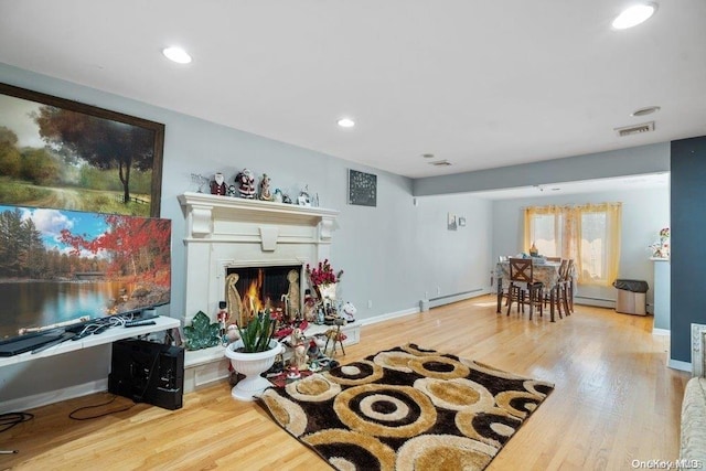 living room with light wood-type flooring and baseboard heating