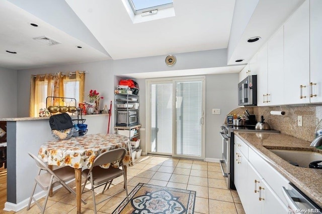 kitchen featuring decorative backsplash, light stone counters, white cabinetry, and appliances with stainless steel finishes