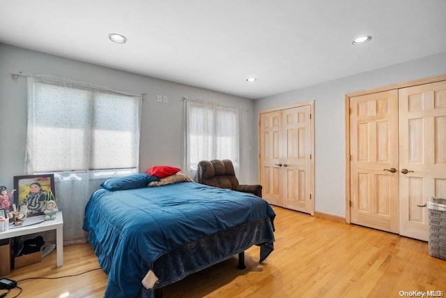 bedroom featuring light hardwood / wood-style flooring and two closets