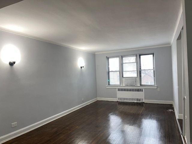 unfurnished room with dark hardwood / wood-style floors, radiator, and crown molding