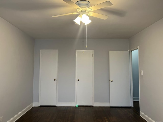 unfurnished bedroom with ceiling fan and dark wood-type flooring