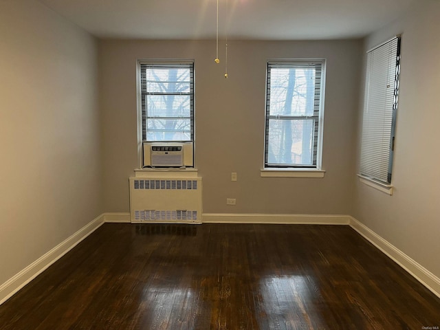 unfurnished room featuring dark wood-type flooring, radiator, and cooling unit