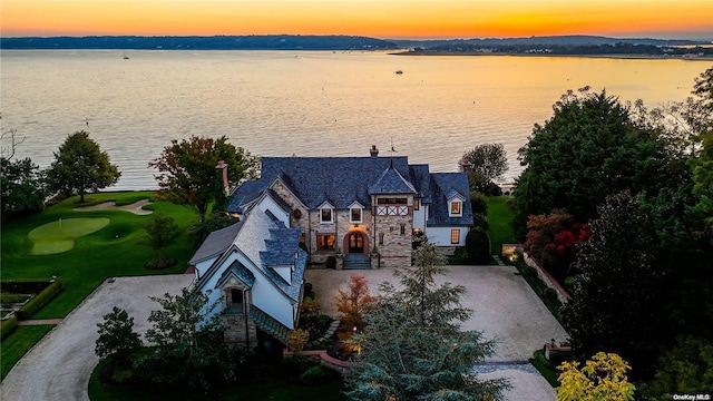 aerial view at dusk featuring a water view