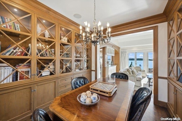 dining space with crown molding, dark hardwood / wood-style floors, and a notable chandelier