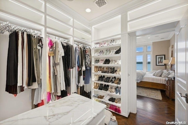 walk in closet with dark parquet floors