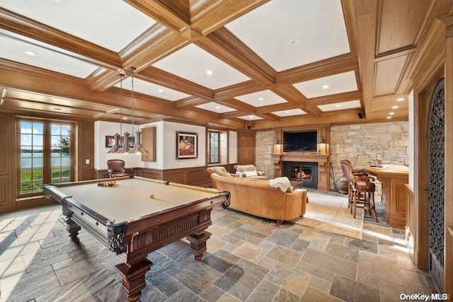 recreation room with beamed ceiling, a stone fireplace, and coffered ceiling