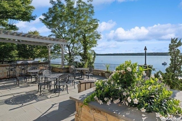 view of patio / terrace featuring a pergola and a water view