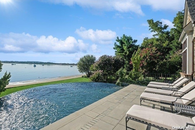 view of pool featuring a patio area and a water view