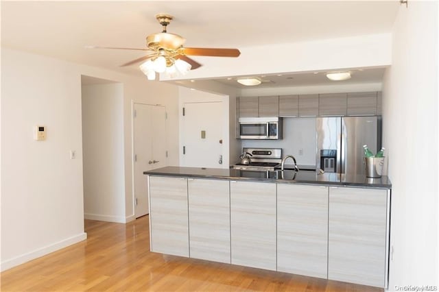 91-16 Shore Front Pkwy Unit 6I, Seaside, NY 11693 - kitchen featuring stainless steel appliances, dark countertops, modern cabinets, and light wood finished floors