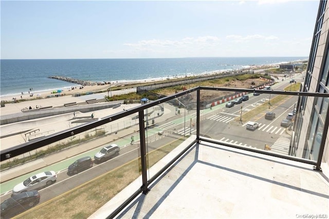 balcony featuring a water view and a view of the beach