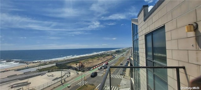 balcony featuring a view of the beach and a water view