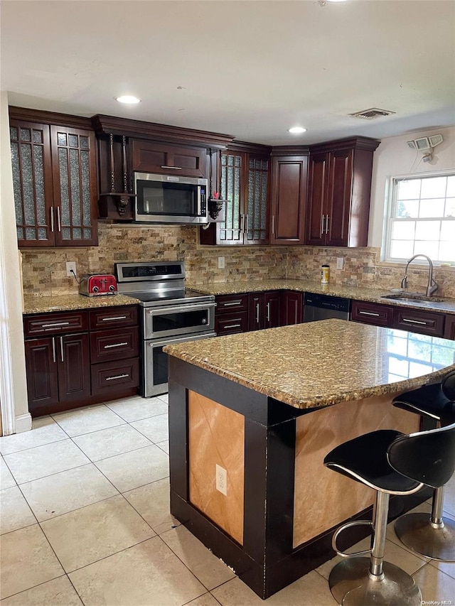 kitchen featuring light tile patterned floors, backsplash, stainless steel appliances, and sink