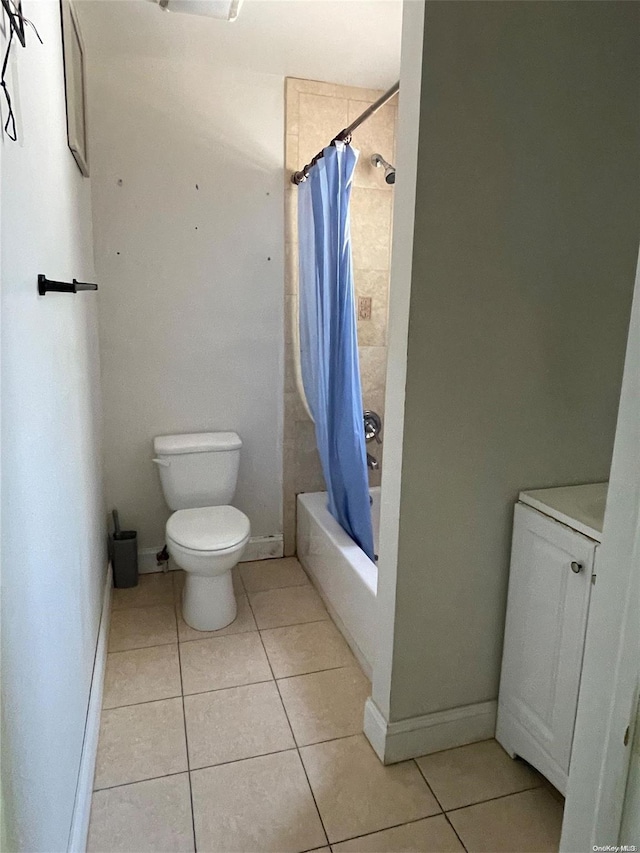 bathroom featuring tile patterned flooring, toilet, and shower / bath combo with shower curtain