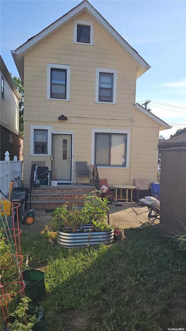 back of house with a patio area and a lawn