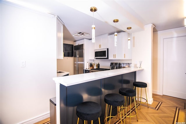 kitchen featuring pendant lighting, a breakfast bar, white cabinetry, kitchen peninsula, and stainless steel appliances